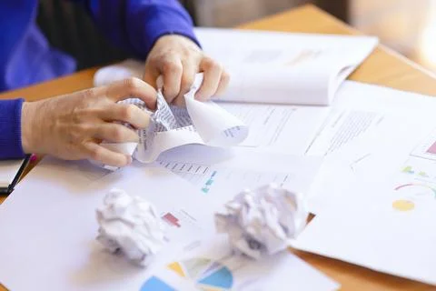 Women's hands crumple the scribbled sheets of paper, anger, rage, irritation. Stock Photos