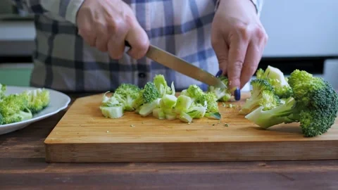 Women's hands cut broccoli on a cutting board with a knife. healthy eating Stock Footage 166464020
