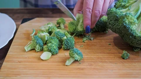 Women's hands cut broccoli on a cutting board with a knife. healthy eating Stock Footage 166524113