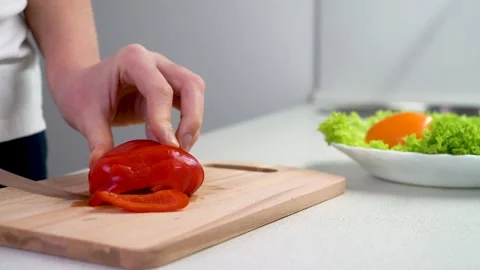 Women's hands cut red pepper close-up, 4K video. Stock Footage 143457887