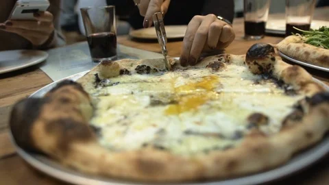 Women's hands cut slice of warm pizza with roller-knife in pizzeria Stock Footage 106722151