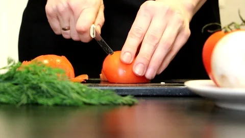 Women's hands cut tomato Stock Footage 98074248