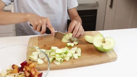 Women's hands cutting apple in the kitchen, food preparation with fresh ing.. Stock Footage 303214931