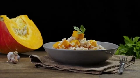 Womens hands decorating the dish. Pumpkin risotto Stockbeeldmateriaal 68713118