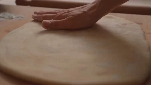 Women's hands dusting flour onto the dough, making dough Stock Footage 229707289