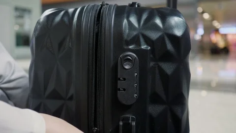 Women's hands fasten the combination lock on the suitcase in airport. Stock Footage 111022792