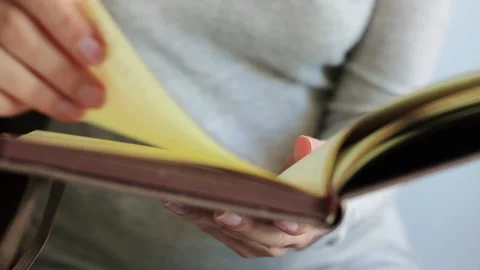 Women's hands flip through the pages of the day book. Video stock 150236189
