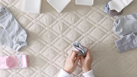 Women's hands fold socks in various convenient ways for storage. Master Class. Stock Footage 233047029