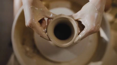 Women's hands form neck of an earthenware jug from white clay on potter's wheel Stock Footage 204741559