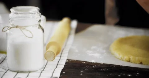 Women's hands form the sides of the rolled dough Stock Footage 182832876