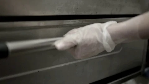 Women's hands in gloves open the oven and put pizza Stock Footage 104518505