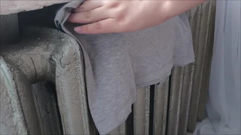 Womens hands hang clothes and towels on the warm radiator Stock Footage 313652630