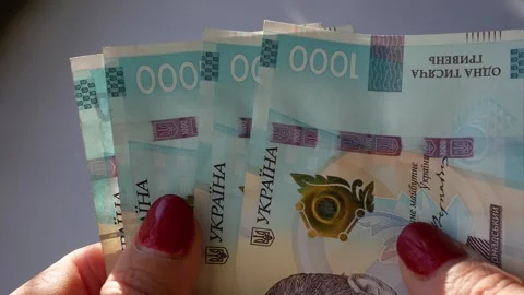Women's hands hold banknotes with a face value of one thousand hryvnias Stock Footage 299893665