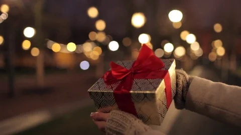Women's hands hold a box with a gift on the street Stock-Footage 83147051