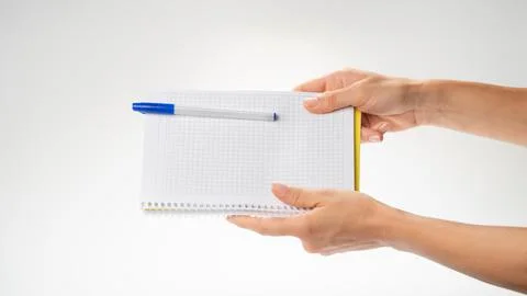 Women's hands hold the notebook with both hands, the gesture passes the notebook Stock Photos