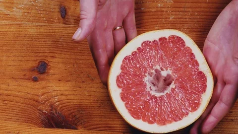 Women's hands holding a grapefruit, close-up Stock Footage 103461642