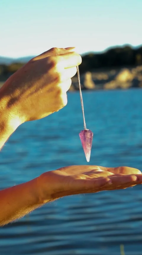 Women's hands holding a pendulum in nature Stock Footage 252135612