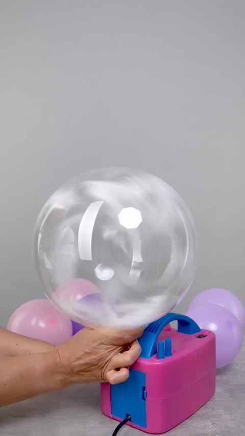 Women's hands inflate a large transparent balloon with a compressor and ins.. Stock Footage 312336733