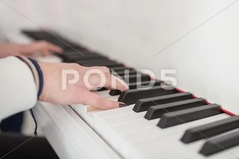 Women's hands on the keyboard of the piano Stock Photos