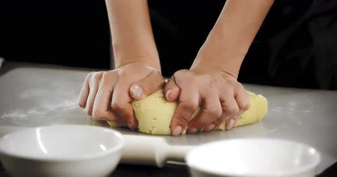 Women's hands knead the dough for shortbread cookies on a silicone mat. Stock Footage 180920792