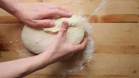 Women's hands knead, stretch and fold the dough in the form of an envelope Stock Footage