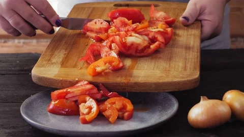 Women's hands with a knife from the board shift the chopped tomatoes into a plat Vídeos de archivo 218257089