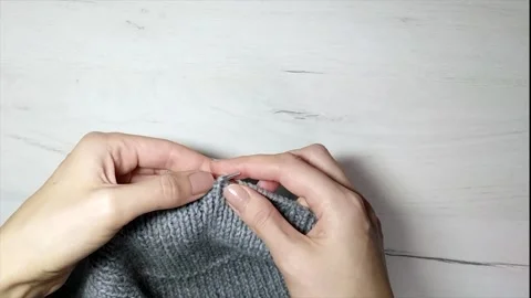 Women's hands knit from grey wool at home Stock Footage 142966796