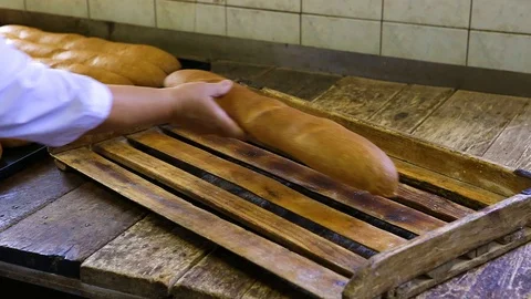 Women's hands lay out fried baguettes on a wooden tray on the table. Close-up Stock Footage 128304627