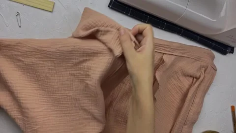 Women's hands lay out a ready-made shirt on the table. Video stock 292804023