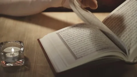 Women's hands leaf through the pages of the Koran Stock Footage 75660728