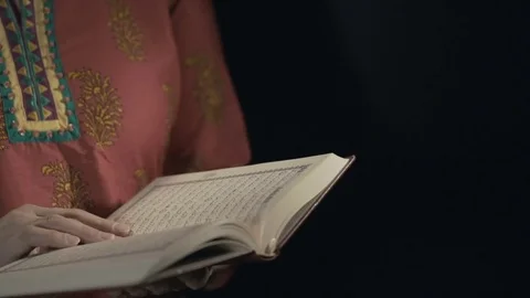Women's hands leaf through the pages of the Koran Stock Footage 75697437