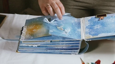 Women's hands leafing through the pages of the scrapbooking photo album Stock Footage 106465965