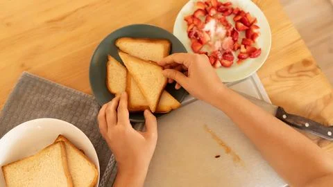 Women's hands make a breakfast of toasted triangles Stock Photos
