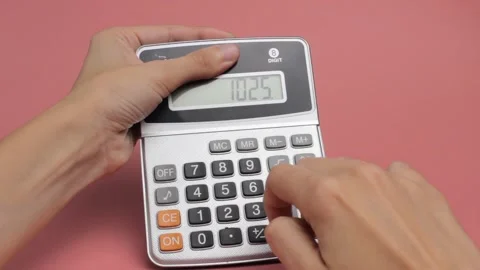 Women's hands make a count on a calculator on a pink background close-up. Stock Footage 161717798