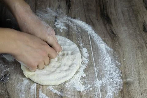 Women's hands make a flatbread for pizza Stock Photos