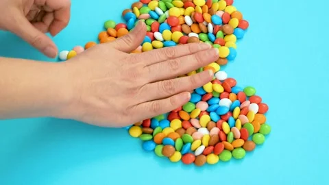 Women's hands make a heart out of candy Stock Footage 162111104