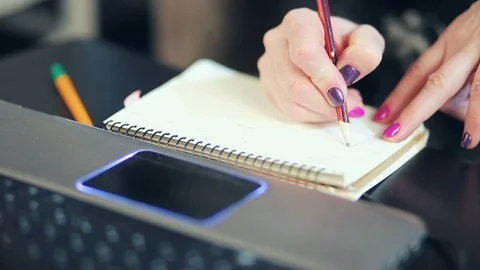 Women's hands make a record in a paper notebook Stock Footage 98633449