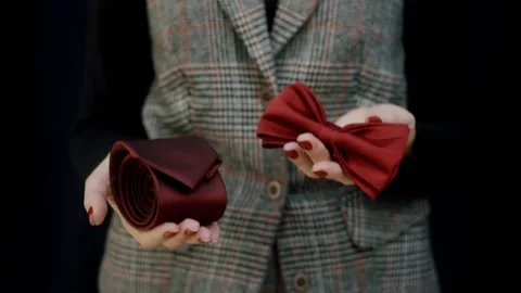 Women's hands offer a choice of bow tie or silk tie for business success.  Stock Footage 165138462