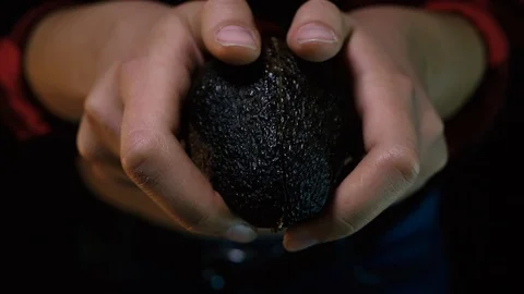 Women's hands open avocado on black screen Stock-Footage 114172018