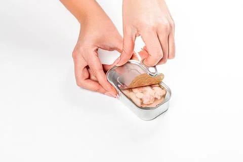 Women's hands open canned cod liver Stock Photos