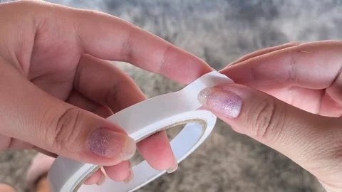 Womens hands open the double-sided tape in close-up. Adhesive tape for repairs. Stock Footage 315152363