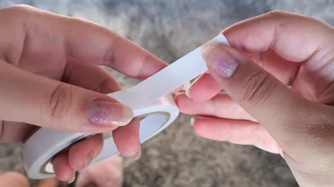Womens hands open the double-sided tape in close-up. Adhesive tape for repairs. Stock Footage 315152679