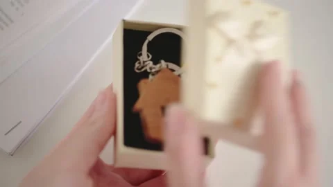 Women's hands open a gift box with a keychain with keys to the apartment Stock Footage 153917789