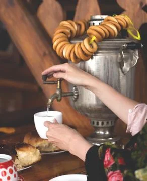 Women's hands opened the tap of the samovar and took hot water in a mug of te Stock-Fotos