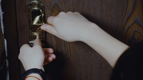 Women's hands opens and closes brass door handles Stock Footage 102345324