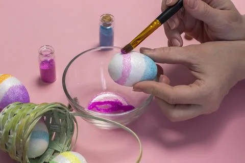 Women's hands to paint Easter eggs. easter holiday concept. Stock Photos