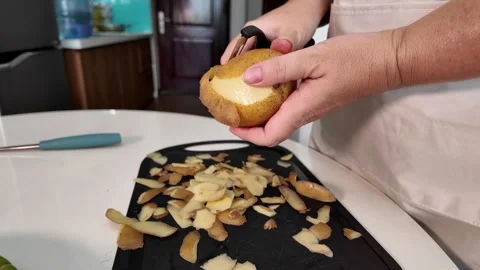 Womens hands peel raw potatoes with a special knife for peeling vegetables Stock Footage 319338754