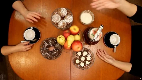 Women's hands pour tea into blue cups on a wooden table, top view Stock Footage 82715524