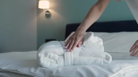 Women's hands put a clean folded robe on the bed Vidéo 252659884