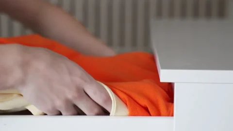 Women's hands put clothes in chest of drawers. Concept of order in the storage Stock Footage 150827335